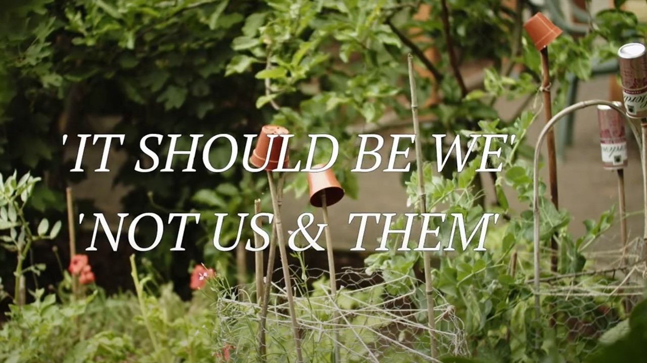 Vegetable garden with text overlay title of poem 'It should be we not us and them'